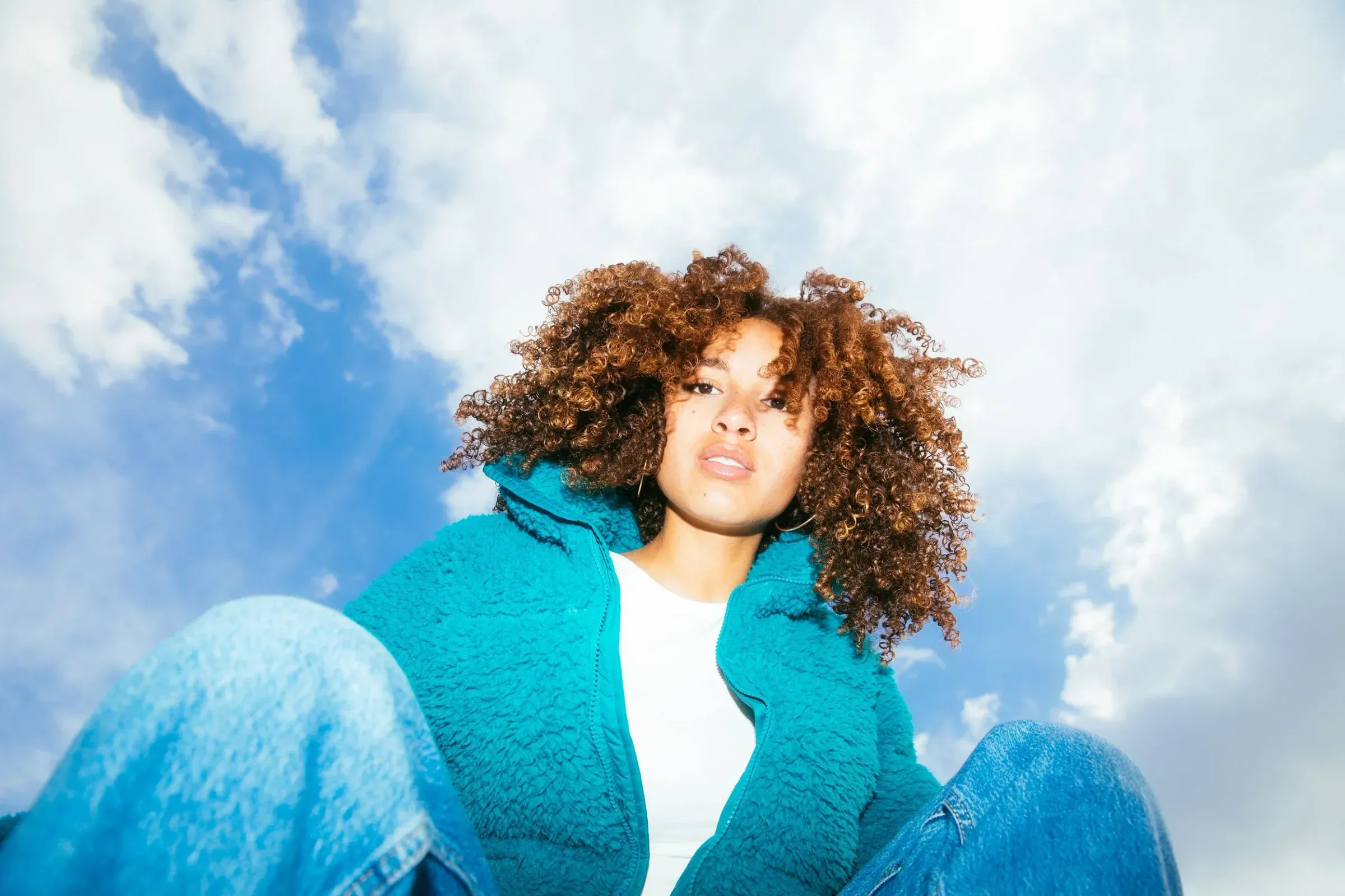 Low Shot of Sitting Woman With Curly Hair